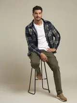 Sobrecamisa a cuadros azul, verde y blanco, con cuello camisero, cierre frontal con botones, dos bolsillos de parche con botón en el pecho y puños abotonados.