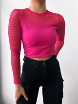Top fucsia de mangas largas, con cuello redondo y corte crop. La parte superior del pecho y las mangas son de red.