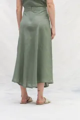 Falda midi color mostaza, de lino, con corte evasé y cintura alta.