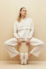 Canguro color beige de la línea Essence, con capucha, corte amplio y detalle de recorte frontal.