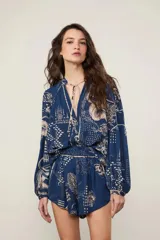 Short de tiro alto con cintura elastizada fruncida, bolsillos laterales y estampado integral de dragones y flores sobre base azul.
