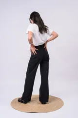 Pantalón wide leg de tiro alto confeccionado en denim negro, adornado con brillos de strass distribuidos por todo el frente.