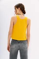 Musculosa de algodón color amarillo vibrante, con escote redondo pronunciado y corte al cuerpo.