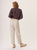 Pantalon de corte recto y tiro medio, confeccionado en tejido de lana con sutiles rayas verticales. Presenta bolsillos traseros aplicados, costuras reforzadas en las rodillas y ruedo con dobladillo.