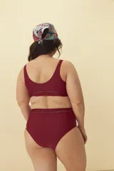 Bombacha de bikini tiro alto color negro, con detalle de calado horizontal en la cintura.