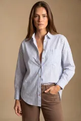 Camisa oversize de manga larga con diseño de rayas verticales verdes y blancas, confeccionada en mezcla de viscosa y lino. Presenta cuello camisero, cierre frontal con botones, puños abotonados y un bolsillo aplicado en el pecho.