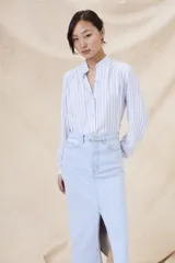 Camisa de manga larga con cuello mao y estampado a rayas verticales celestes y blancas.