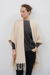 Ruana de tejido de punto en color negro, con diseño de cuello alto y terminaciones con flecos en los bordes.