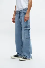 Pantalón de jean celeste con corte amplio, bolsillos laterales tipo cargo y tiro medio.