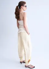 Pantalón balloon de tiro medio en color beige, con detalle de pinzas y bolsillos laterales.