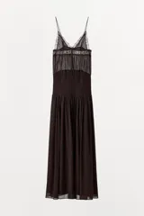 Vestido largo de tirantes finos con escote en pico, cuerpo con frunces elásticos y detalle de encaje a tono en la parte superior. Cuenta con forro interior y falda fluida.