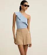 Short sastre de cintura alta color marrón, con bolsillos laterales y detalles de tachuelas metalizadas.
