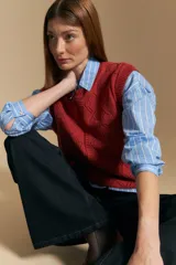 Chaleco tejido color crema con diseño de rombos calados, cuello redondo y sisas.