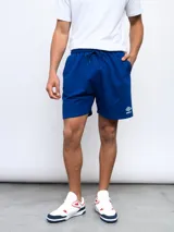 Bermuda de felpa color celeste, con cintura elástica y cordón de ajuste. Presenta el logo Umbro bordado en la pierna izquierda.