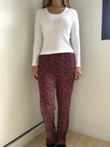 Pantalón de pijama de corte recto y holgado, con cintura elástica y cordón ajustable. Presenta un estampado de puntos blancos sobre fondo bordó.