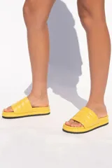 Sandalia tipo slipper color camel, confeccionada en cuero vacuno, con capellada acolchada y plataforma ergonómica forrada a tono.