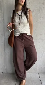 Blusa de punto sin mangas en color natural, con textura fruncida en todo el diseño y cuello redondo.