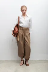 Pantalón de vestir azul eléctrico con pinzas, tiro alto, corte ancho y cinturón marrón con hebilla metálica con forma de sol.