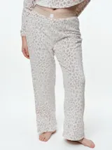 Pantalón de dormir de corte recto confeccionado en tela fleece con estampado animal print. Presenta una cintura elástica de algodón en color gris y una textura suave y abrigada.
