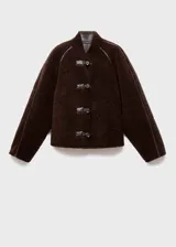 Chaqueta reversible de corte recto y diseño oversize, confeccionada en efecto cuero con interior de borreguito. Presenta cuello alto, cierre frontal con botones y mangas largas.