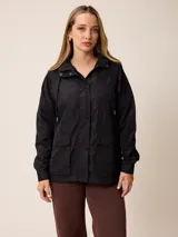 Campera negra de estilo casual con capucha, cierre frontal con botones a presión y bolsillos frontales con solapa. Presenta un diseño funcional con cordones ajustables en la capucha.