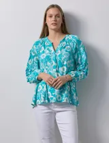 Blusa de gasa estampada marca Zac & Rachel. Tiene cuello a la base, escote en V con apertura y botones. Las mangas son 3/4 con frunce. Tiene detalle de crochet en hombros y delantera.