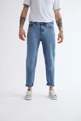 Pantalón jean celeste de corte mom, con tiro alto y tobillos ajustados.