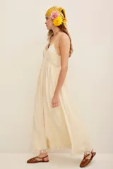 Vestido largo color marfil con tirantes finos, escote en V y aplicaciones de encaje floral en el pecho, la cintura y el ruedo.