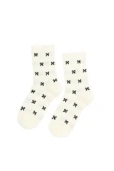 Medias de caña media en tejido rib color crema, con estampado de pequeños lazos negros distribuidos por toda la prenda.