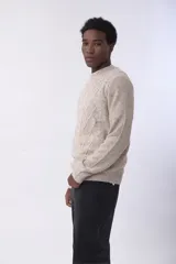 Sweater de punto con diseño de rombos en relieve, color beige jaspeado, de cuello redondo y manga larga.