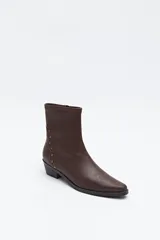 Bota corta de caña elástica, color negro, con puntera cuadrada y taco bajo. Presenta detalles de remaches metálicos plateados en el lateral exterior.