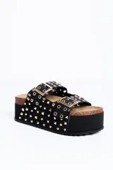 Sandalia plataforma color negro, con doble tira ancha con hebillas y tachas doradas, suela de corcho y plataforma alta texturizada.