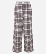 Pantalón de pijama de franela con estampado de cuadros en tonos marrón y blanco. Presenta un corte holgado, cintura elástica y diseño cómodo ideal para el descanso.