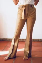 Pantalón acampanado color naranja, de paño de lana elastizado, con lazo en la cintura.