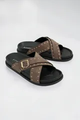 Sandalias negras de tiras cruzadas decoradas con tachas doradas, con hebilla lateral ajustable y suela anatómica.