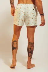Short de baño rosado con estampado tropical de palmeras y vehículos, con cintura elástica con cordón ajustable.