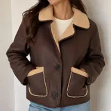 Campera gamulán de ecocuero marrón con forro y detalles de corderito en cuello, solapas y bolsillos. Cuenta con cierre frontal de botones y dos bolsillos aplicados.