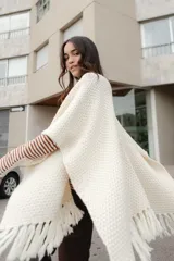 Ruana tejida en lana merino color ladrillo, con textura de punto grueso.