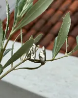 Anillo de diseño orgánico y macizo con forma irregular, elaborado en metal con acabado brillante. Presenta una estructura abierta que permite su ajuste.