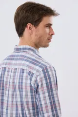 Camisa de manga larga de calce slim, con diseño a cuadros en tonos azul oscuro, verde y blanco. Presenta cuello camisero con botones y bolsillo ojal en el pecho con detalle bordado.