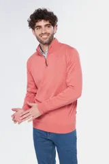 Buzo de tejido fino en hilo de algodón, color rosado, con cuello alto y cierre frontal parcial con detalle en cuero. Presenta puños y ruedo acanalados y un pequeño logo bordado en el pecho.