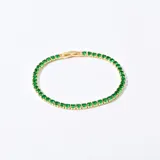Pulsera dorada con engarce de piedras verdes.