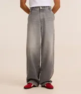 Pantalon baggy de jean gris con efecto deslavado, tiro medio, cierre con boton y cremallera, trabillas para cinturon y bolsillos delanteros y traseros.