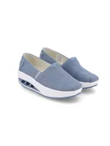 Zapatillas tipo slip-on Hush Puppies modelo Angelo, confeccionadas en tela canvas color azul denim. Presentan una suela de plataforma con tecnología de amortiguación y plantilla de memory foam.