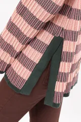 Buzo de tejido de punto con diseño de rayas horizontales en tonos rosado y gris oscuro, cuello alto y mangas largas con puños rectos.