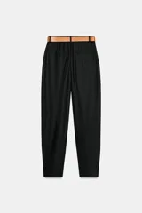 Pantalón tobillero azul marino de tiro medio, con pinzas delanteras, bolsillos frontales, falsos bolsillos con solapa en la espalda y cierre frontal con cremallera, botón y gancho. Incluye cinturón de cuero sintético tostado con hebilla metálica dorada.