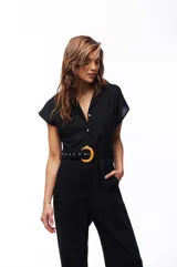 Mono negro con cuello camisero, mangas cortas, cinturón con hebilla circular de bambú y bolsillos laterales.