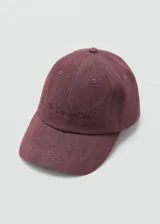 Gorra tipo baseball color bordó, confeccionada en algodón con efecto lavado. Presenta visera curva, mensaje bordado sutil en el frente y cierre posterior regulable con hebilla metálica.