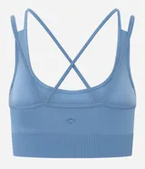 Top deportivo Get Over confeccionado en poliamida seamless, con escote redondo, breteles cruzados en la espalda y diseño sin costuras para mayor comodidad.