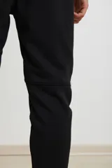 Pantalón jogging de corte slim, con puños elastizados, cintura con cordón ajustable, cierres laterales engomados y bolsillo tipo parche lateral.